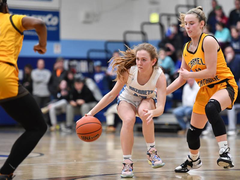 Nazareth's Mary Bridget Wilson (middle) starts a move as she is double teamed by Carmel during the ESCC conference tournament championship game on Feb. 4, 2023 at Nazareth Academy in LaGrange Park.