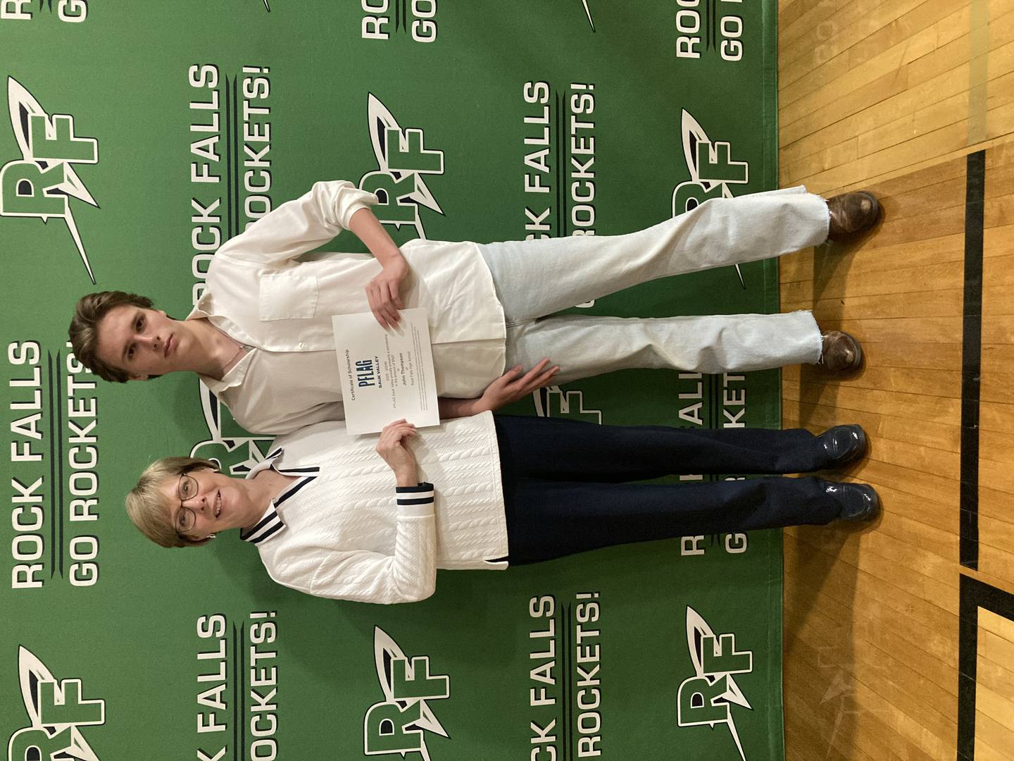 John Thompson (right) receives a $500 scholarship from PFLAG Sauk Valley President Sarah Schlegel.