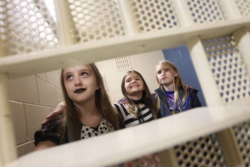 Emilia Mazzuca, Savanna Witt and Delaney Cullen, all 9, of Lake Villa react to being in a jail cell as they check it out during the Halloween Howl at the Village of Fox Lake Police Department.