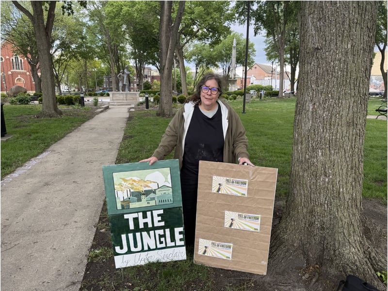Abby McCague, an Ottawa resident, participating in Friday night's "May Day Rally" at Washington Park in Ottawa. McCague was supporting Fall of Freedom, contributing artwork and signs for the protestors, as well as drawing artwork and writing messages on the sidewalks in chalk.