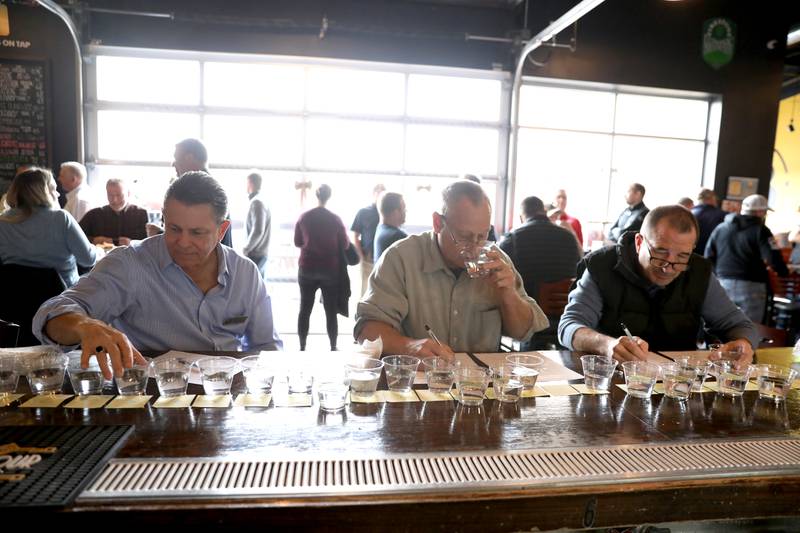 (From left) Judges Cliff Surges, Dan Mann and Paul Young taste the samples in the annual Kane County Water Association's annual water-tasting contest at Global Brew in St. Charles on Thursday, Dec. 21, 2023.