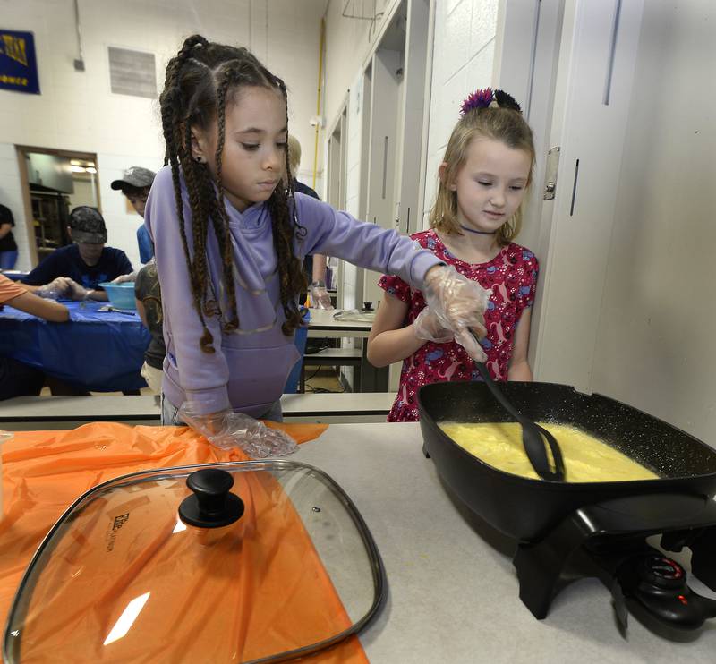 Athia McKinnie and Hallie Klass work together to stir battered eggs Friday, June 30, 2023, at Northlawn Junior High School in Streator during the Illinois Junior Chefs class. The University of Illinois Extension, OSF Health, Live Well Streator and Streator Salvation Army coordinated the weeklong program.