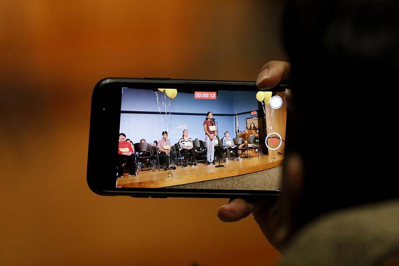 A parent takes a photograph of their daughter as she competes in the McHenry County Regional Office of Education 2023 Spelling Bee Wednesday, March 22, 2023, at McHenry County College's Luecht Auditorium in Crystal Lake.
