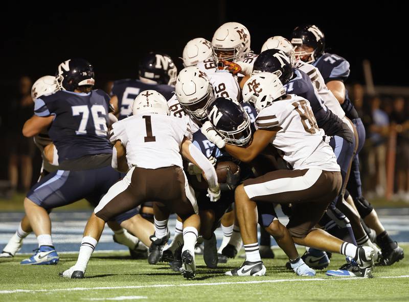 Nazareth's Justin Watson (23) is wrapped up by the Mt. Carmel defense during the varsity football game between Mt. Carmel high school and Nazareth Academy on Friday, Sept. 12, 2025 in La Grange Park, IL.