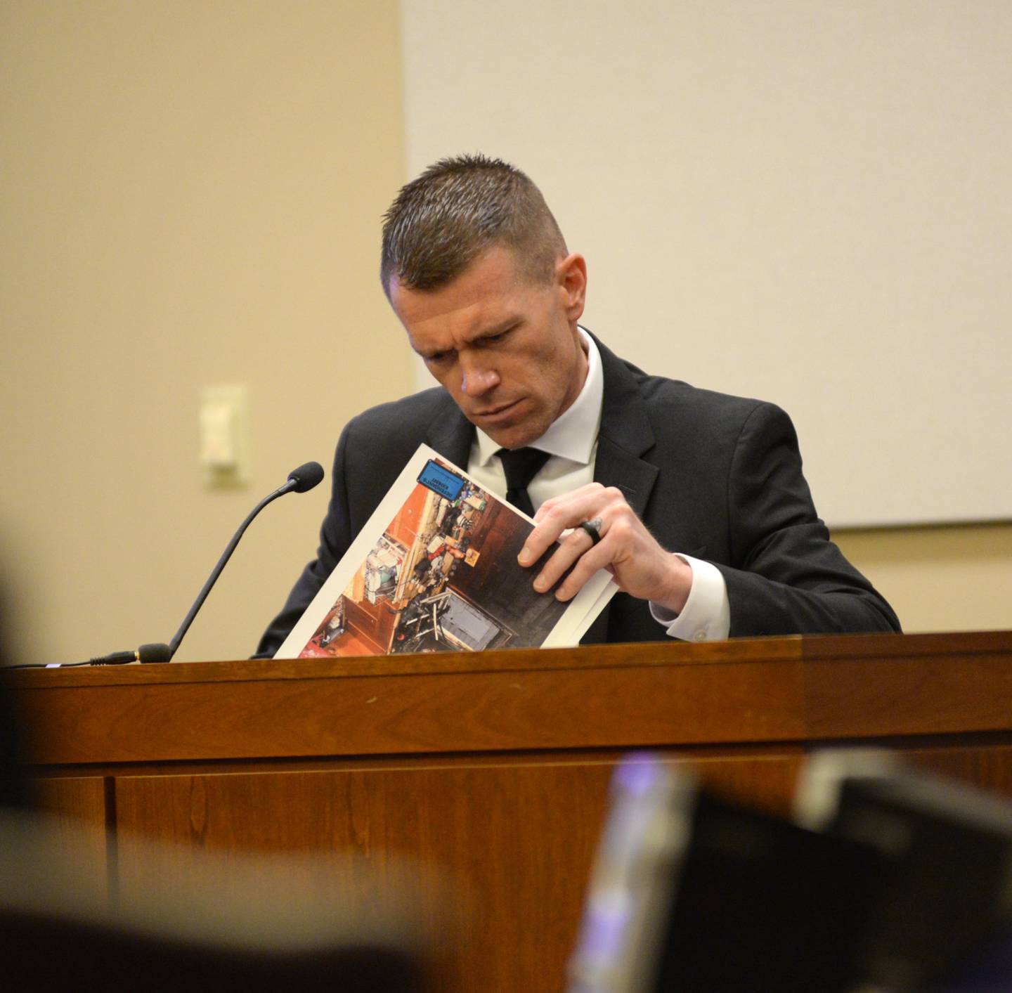 Illinois State Police Crime Scene Investigator Jeff Thew looks over photos as he testifies during the Matthew Plote trial at the Ogle County Judicial Center in Oregon on Tuesday, March 19, 2024.