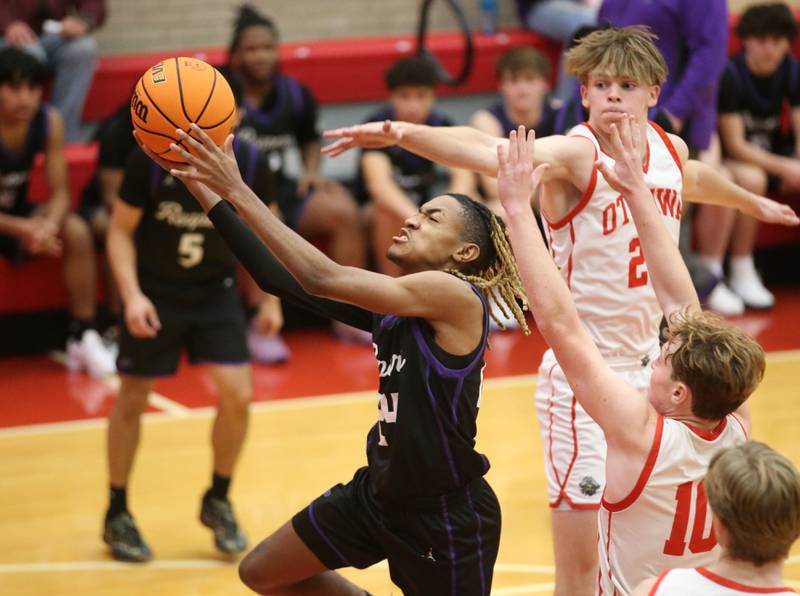 Plano's Jamarion Thurston eyes the hoop as Ottawa'sOwen Sanders and Evan Snook defend during the Dean Riley Shootin' The Rock Thanksgiving Tournament on Tuesday, Nov. 26, 2024 in Kingman Gym at Ottawa High School.