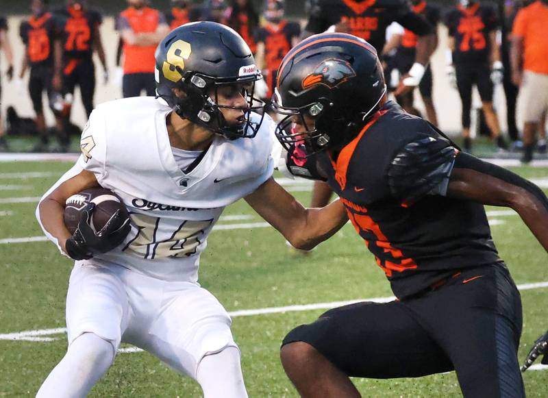 Sycamore's Josiah Mitchell tries to avoid DeKalb's Davon Grant Friday, Aug. 30, 2024, during the FNBO Challenge at Huskie Stadium at Northern Illinois University.