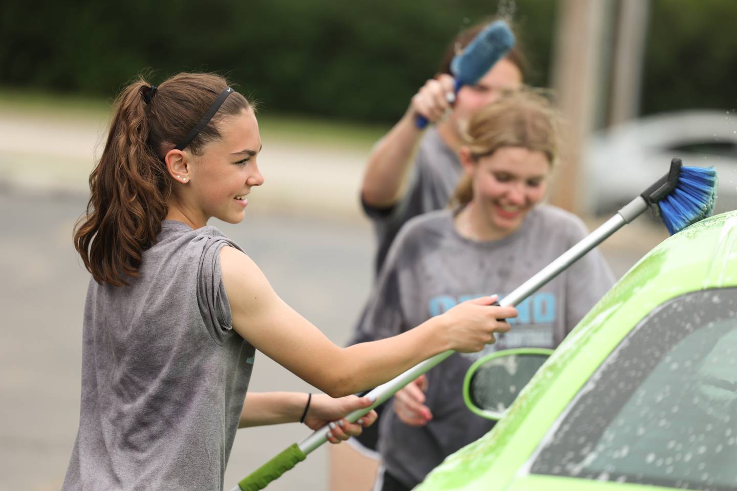 Kate Richardson washes a car for a fundraiser. The Rhino 13U Softball team took advantage of the warm weather to hold a car wash to raise funds for the team. Monday, June 13, 2022 in Joliet.