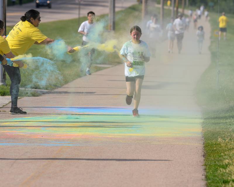Chloe Streit, 10,  of Rochelle , get sprayed with color powder on Saturday, June 7, 2025, during the CASA DeKalb County 5K Color Run held at the Sycamore Middle School.