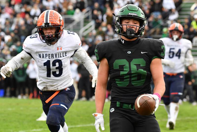 Glenbard West's Jack Moellering (36) finishes an easy glide into the end zone ahead of Naperville North's William Korosec (13) for his second touchdown during an IHSA Class 8A playoff game on Oct. 28, 2023 at Glenbard West High School in Glen Ellyn.