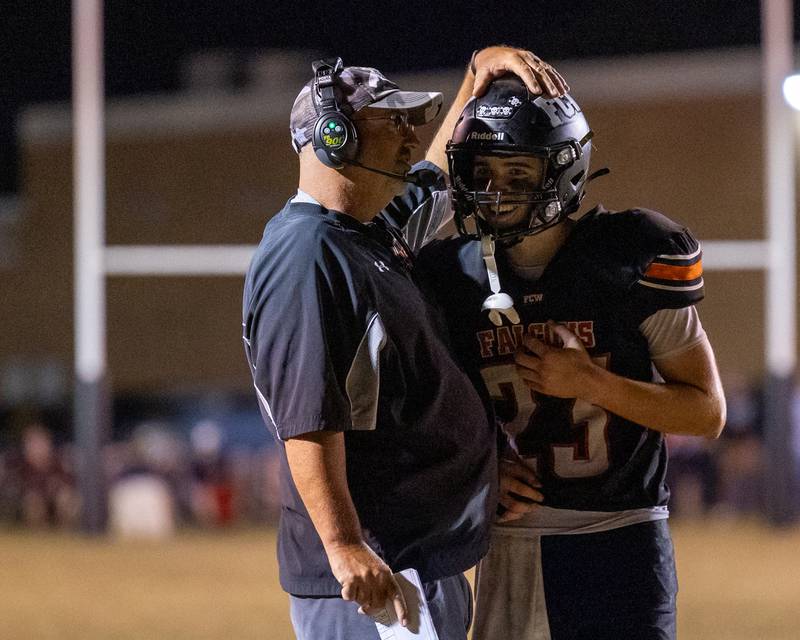 FCW Head Coach, Todd Reed embraces player Brezdyn Simons (23) after a play on Friday, Sept. 26, 2025 at Woodland High School in Streator.