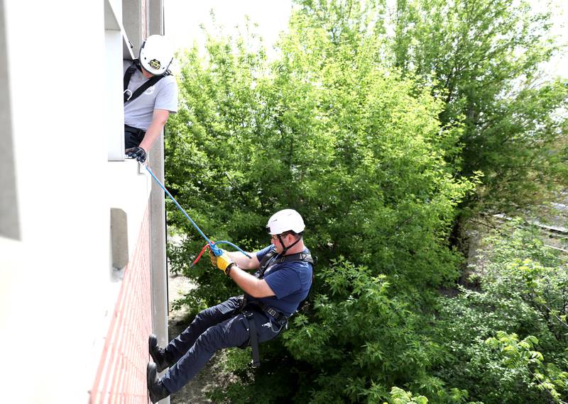Geneva Fire Engineer Matt WIlliams rappels down the side of the Third Street Commuter Parking Deck as Lt. Andrew Shad looks on from above during a training exercise on Tuesday, May 13, 2025 in Geneva.