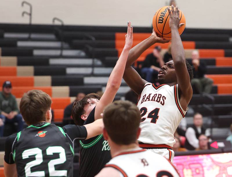 DeKalb's Myles Newman shoots over two Rock Falls defenders during their game Tuesday, Dec. 2, 2025, at DeKalb High School.