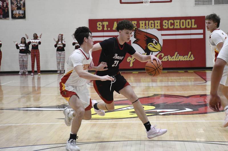 Momence's Tommy Rounds drives with the ball with St. Anne's Matthew Langellier guarding during St. Anne's 61-46 victory over Momence on Tuesday December 9, 2025.