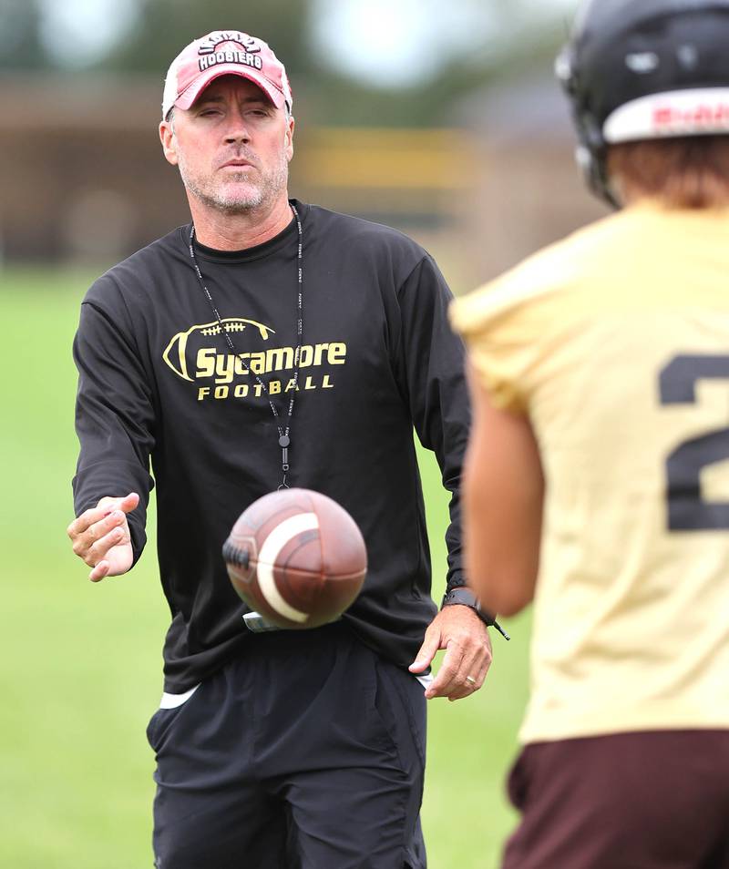 Sycamore head coach Joe Ryan snaps the ball to quarterback Elijah Meier Monday, Aug. 8, 2022, at the school during their first practice ahead of the upcoming season.
