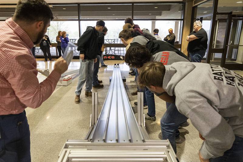 Teams watch as their cars race down the runway Friday, April 26, 2024.