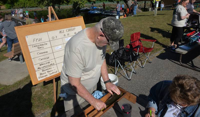 David Schipper, a retired Whiteside County Sheriff employee, measures a fish during the annual fishing derby at Morrison-Rockwood State Park in Morrison on Saturday, Sept. 9, 2023.