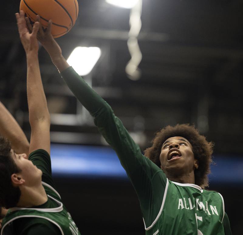 Alleman’s DJ Baker reaches for a rebound against Sterling Friday, Dec. 20, 2024, at Sterling High School.