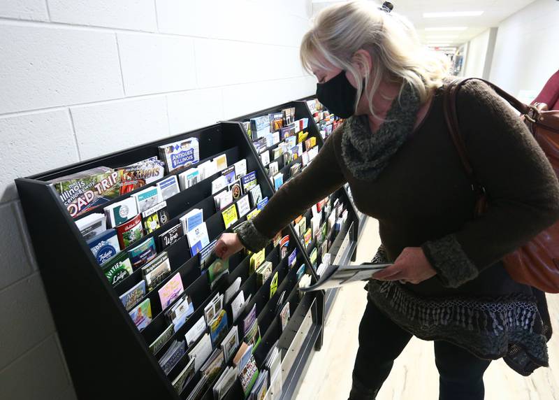 Beth Wisdom, of Aurora, browses through a brochure rack at the new Heritage Corridor Visitors Center in Utica on Wednesday Jan. 26, 2022.