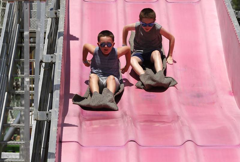 Brothers Jack and Trace Hermansen race down the Fun Slide during Lakeside Festival on Thursday, July 3, 2025, on the grounds of the historic Dole Mansion in Crystal Lake,