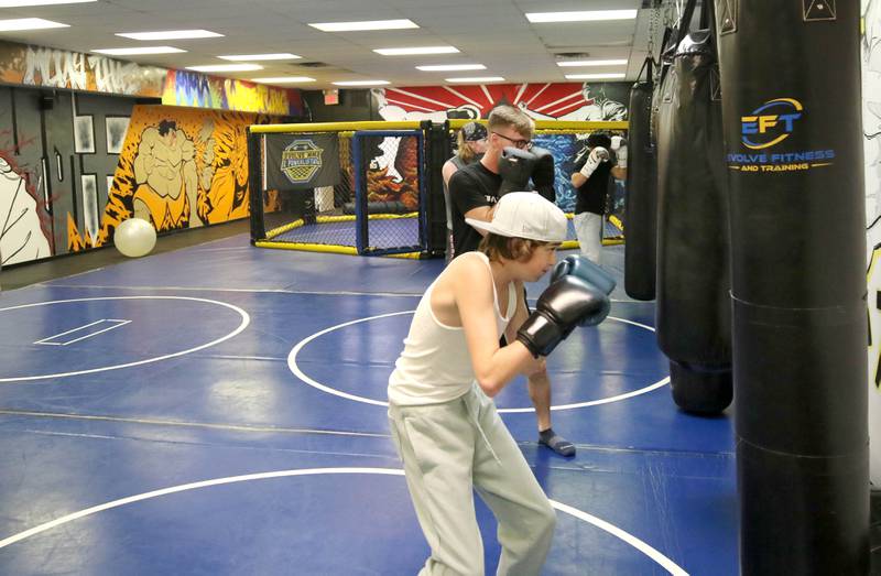 Students punch the heavy bag at Evolve MMA and Powerlifting during a class Thursday, Nov. 9, 2023, at the facility in DeKalb.