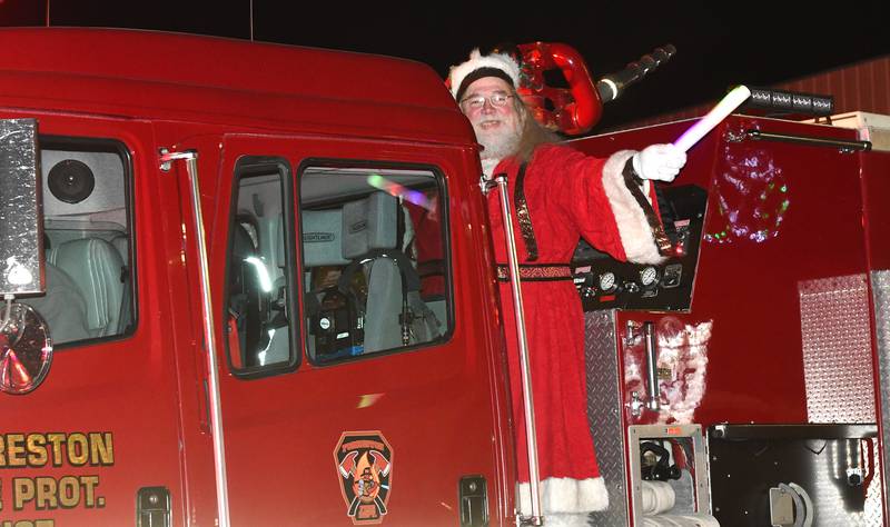 Santa Claus waves to the crowd as he arrives at Forreston's Christmas in the Country on a firetruck on Friday, Dec. 5, 2025.