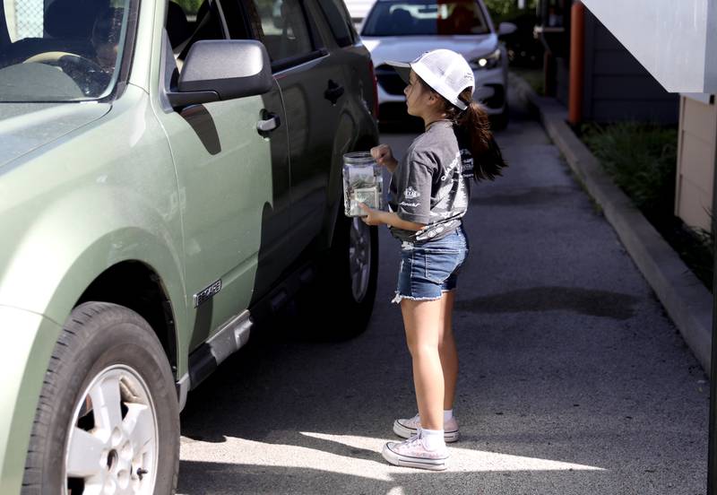Elena Fregoso, daughter of St. Charles Community Service Officer Francisco Fregoso, collects donations at Dunkin’ Donuts on East Main Street in St. Charles on Friday, May 16. 2025 for the Cop on a Rooftop fundraiser for Special Olympics Illinois.