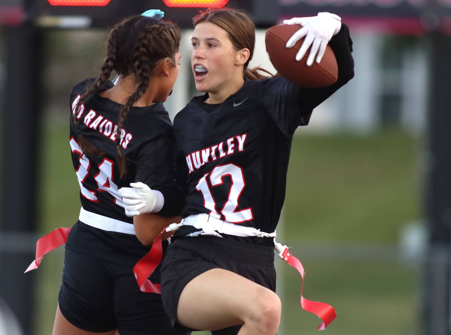 Huntley’s Aubrina Adamik, right, is greeted by Natalia Turk after a touchdown against McHenry in varsity flag football at Huntley High School in Huntley on Tuesday, Sept. 9, 2025.