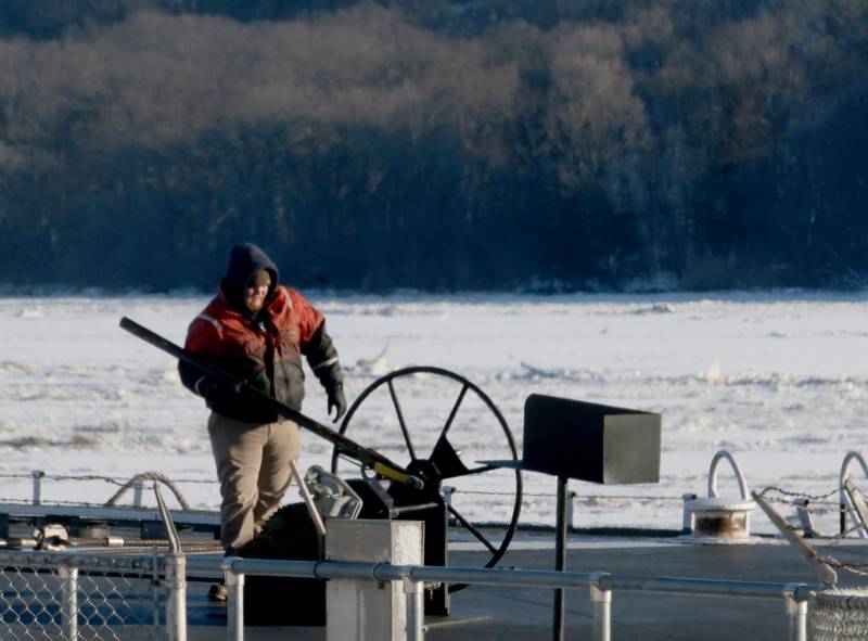 A crew member works outside in the cold on top of a tanker barge on Tuesday, Jan. 16, 2024, at the Starved Rock Lock and Dam.