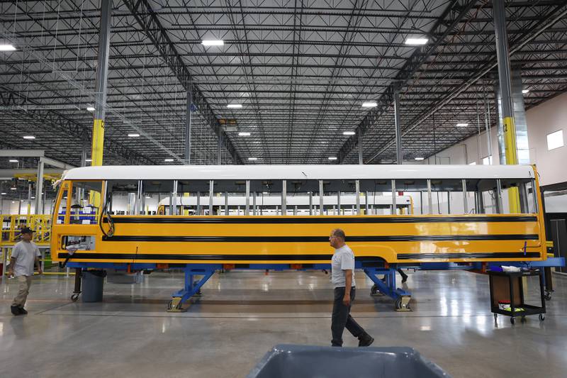 A worker walks past the shell of a bus at the Lion Electric manufacturing facility on Friday, July 21st, 2023 in Joliet.