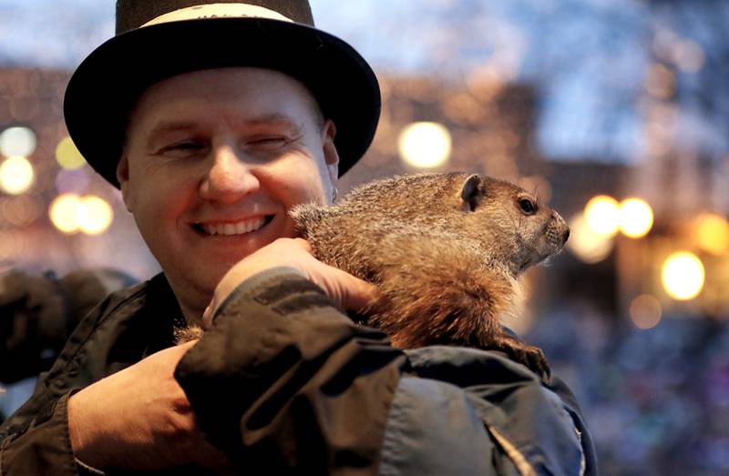 Woodstock Willie is held by handler Mark Szafran as Willie looks to see if he can see his shadow on Sunday, Feb. 2, 2025, during the annual Groundhog Day Prognostication in the Woodstock Square.