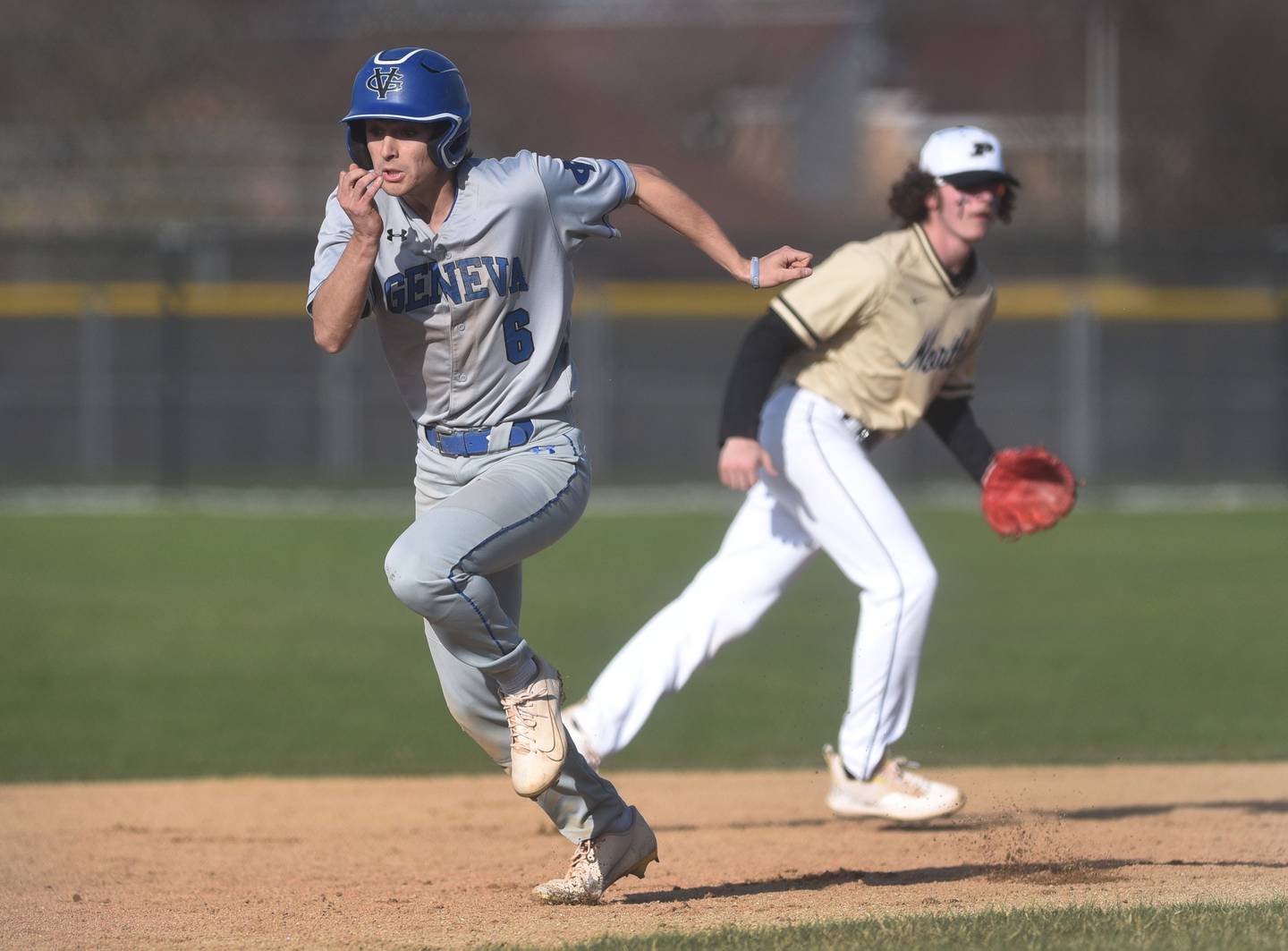 Geneva's John Frieders (6) heads to third base as Glenbard North's Josh Christman eyes the ball during Tuesday’s baseball game in Carol Stream.