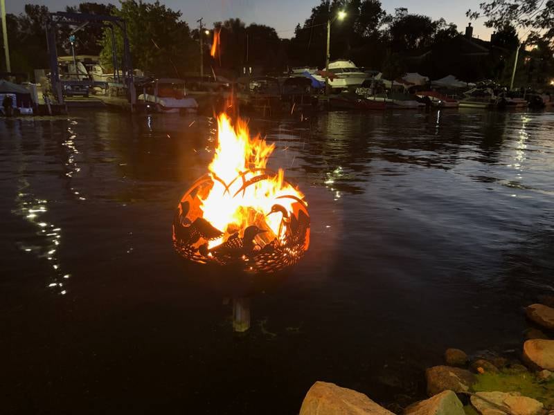 One of several fire globes is aglow in McHenry on Saturday, Sept. 27, 2025 during the annual Light the Night. The city lights fires in the 15 fire globes sitting in the water along the McHenry Riverwalk.