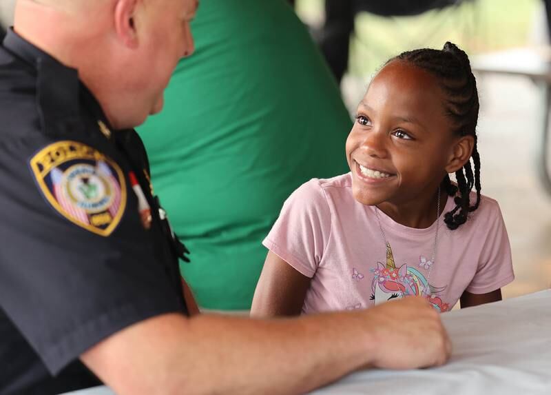 Mariah Cotton, 10, from DeKalb, talks with DeKalb Deputy Police Chief Jason Leverton after beating him in Uno during Fun Jam in the Park Tuesday, June 27, 2023, at Welsh Park in DeKalb. Fun Jam in the Park offers constructive activities for kids on Tuesday and Thursday through August 8th from 5-7 p.m. at various parks in DeKalb.