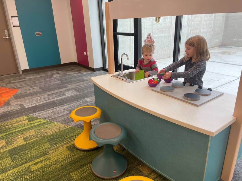 Algonquin Area Public Library's Eastgate Branch reopened Jan. 6, 2025, after a five-month for a $6 million renovation. Algonquin residents Ellen Seletos, 4, and Andrew Seletos, 2, play with a new toy kitchen in the newly added youth services area on the library's lower level.