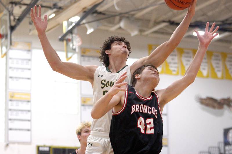 Crystal Lake South’s CJ Regillio, back, and Barrington’s DJ Young go for a rebound in Hinkle Holiday Classic boys basketball tournament game action at Jacobs High School Tuesday.