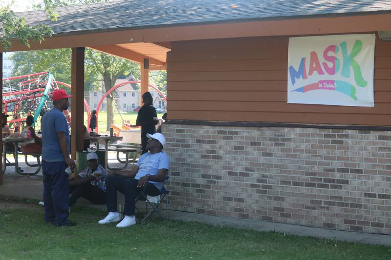 Men gathering outside the gazebo at Welsh Park in DeKalb June 9, 2023 during an event put on MASK in DeKalb.