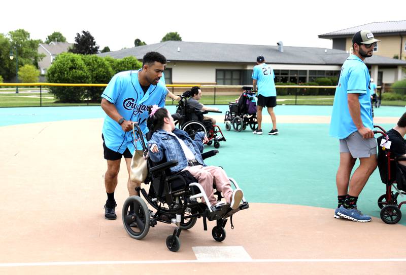 Kane County Cougars outfielder Johah Davis rounds third base with Marklund client Lizzy V. during a softball game at Marklund Hyde Center in Geneva on Tuesday, July 9, 2024.