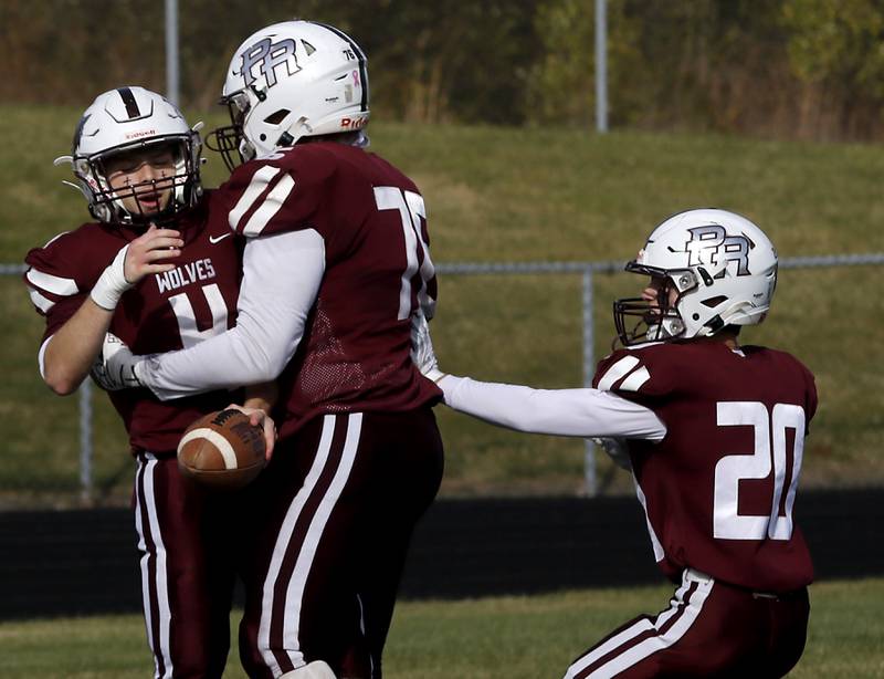 Prairie Ridge's Jack Finn (left)  celebrates with his teammates, David Allen (center)vand Jesse Kautz (right) during an IHSA Class 5A first-round football game on Saturday, Nov. 2, 2024, at Prairie Ridge High School in Crystal Lake.