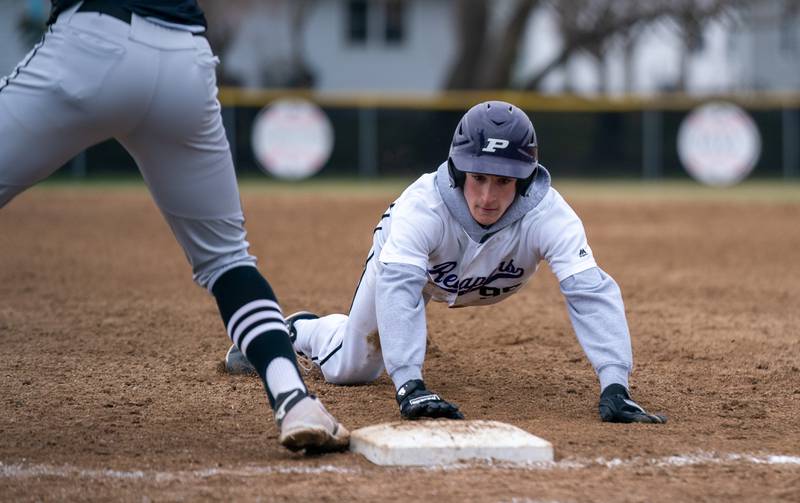 Plano’s Kaden Aguirre (99) dives back to first to avoid a pick off attempt by Sycamore during a baseball game at Plano High School on Monday, April 4, 2022.