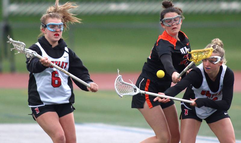 Huntley’s Leah Holmberg, left, and Katie Ferrara, right, battle Crystal Lake Central’s Colleen Dunlea in varsity lacrosse at Huntley Wednesday.