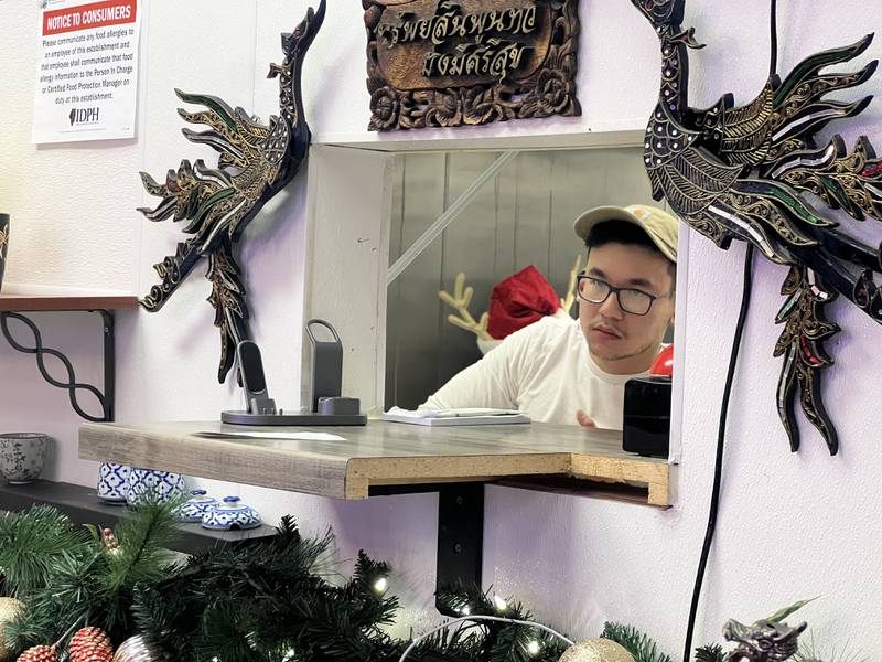 Varintorn Bogaert, 22, works in the kitchen, takes orders from guests, and organizes take out food at his family's restaurant, Thai Town in Sycamore on Dec. 13, 2023.