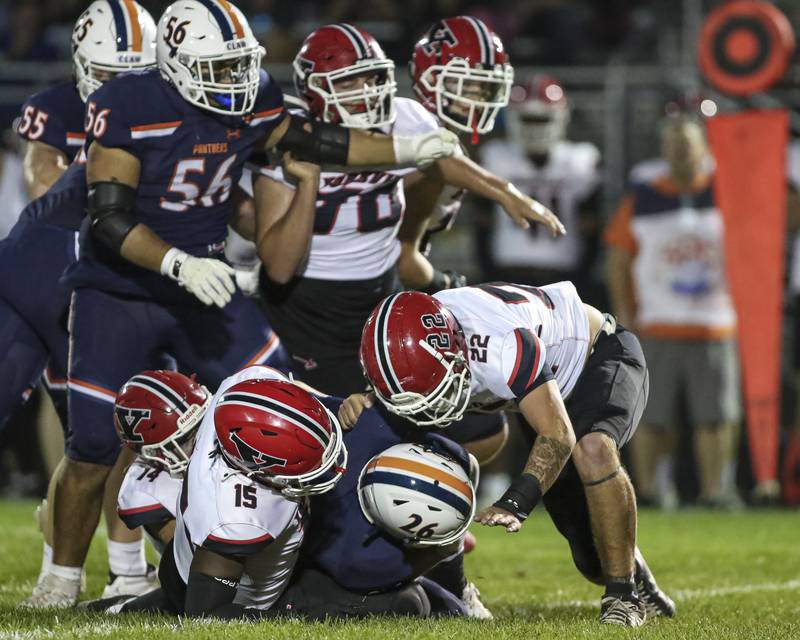 The Yorkville defense gang tackles Oswego's Dekker Zelensek (26) during football game between Yorkville at Oswego Friday, Sept 26, 2025 in Oswego.