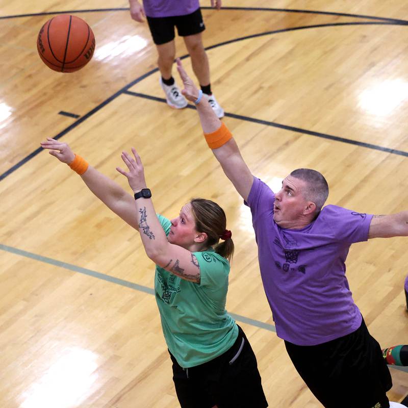 Fire/Police team member Keeley Meyer shoots in front of Sycamore School Staff team member Jeff Hilmer Thursday, Dec. 19, 2024, during the Heroes on Hardwood basketball game at Sycamore High School. The basketball game, which is a fundraiser for the Sycamore Food Pantry, pits a team of Sycamore first responders against a squad of Sycamore School District 427 staff.