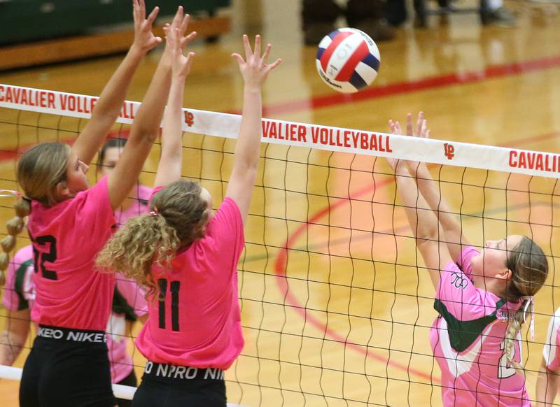 L-P's Kelesy Frederick and teammate Katie Sowers block a spike from St. Bede's Johnna Bogatitus during the "Cavs 4 A Cause" pink night event on Tuesday, Sept. 26, 2023 at Sellett Gymnasium.