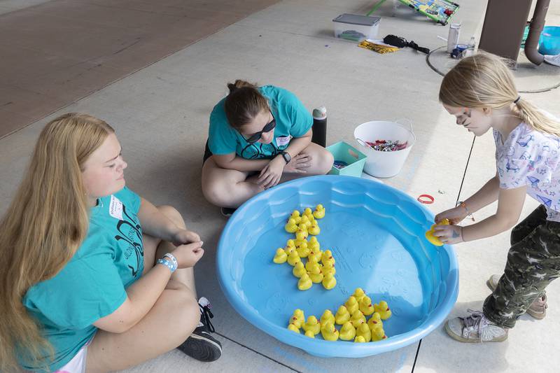 Building Lasting Impressions that Never Die (BLIND) student leaders Madison Hill (left) of Prophetstown and Madilyn Blackburn of Rock Falls watch as Jasmine Jenner, 5, selects a duck during a game Friday, Aug. 2, 2024.