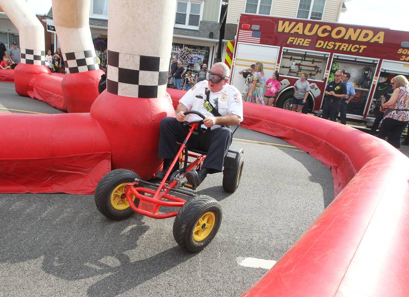 Pat Kane, Wauconda fire chief, wears simulated DUI goggles called, Drunk Busters, as he makes his way around a racetrack in a go-kart on Main Street during National Night Out on Tuesday, August 1st in Wauconda.  
Photo by Candace H. Johnson for Shaw Local News Network.