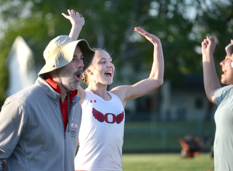 Oregon's Jillian Hammer (center) and her coach Dane Bell (left) react when her official time of 15.50 second was announced after she won the 100 hurdles at the 1A Lena-Winslow sectional on Thursday, May 15, 2025. She will compete at the state meet this week at Eastern Illinois University in Charleston.