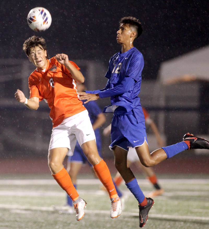 St. Charles East’s Aiden Maloney (left) heads the ball away from St. Charles North’s Diego Torres during a Tri-Cities Night game at St. Charles North on Thursday, Sept. 21, 2023.