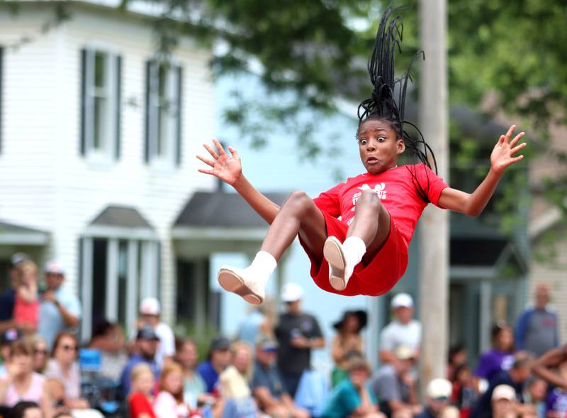 A performer  from the Jesse White Tumblers flies through the Fiesta Days Parade down Main Street in McHenry on Sunday, July 20, 2025.